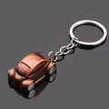 Close-up van een vintage bronzen autosleutelhanger met een klassiek keverontwerp - Antiek Rood