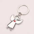 Llavero de ángel de metal plateado con un colgante de corazón rojo y fondo gris - Ángel