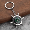 Creative silver ship wheel compass keychain with functional navigation dial on wood background - Ship Wheel Compass Style