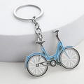 Silver bicycle keychain with blue enamel details on white minimalist display background - Sky Blue
