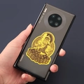 Golden Acala religious metal sticker on black smartphone showing intricate 3D details - Acala - Rooster Zodiac