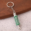 Detailed view of car shock absorber keychain with green coil spring and silver zinc alloy - Green