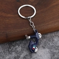 Blue retro scooter keychain with ROMA text and Italian flag on a dark wood background - Deep purple