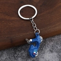 Blue retro scooter keychain with metal ring and Italian style stripes on a wooden surface - Blue