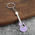 Dettaglio portachiavi a forma di chitarra elettrica viola con manico in metallo e anello - Viola