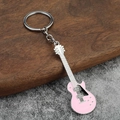 Detail of a pink electric guitar keychain with silver chain on rustic wood background - Pink