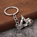 Silver metal motorcycle keychain with Italian flag stripe detail on a wooden surface - White K/Silver