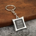 Detail view of the silver metal square photo frame keychain with lobster clasp on wood background - Diamond