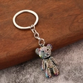 Portachiavi orsetto con strass scintillanti e finitura arcobaleno su pavimento in legno - Iridescente