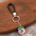 Détail d'un porte-clés disque de frein multicolore avec étrier vert sur plateau bois - Style Étrier Vert
