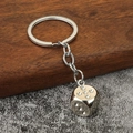 Makro-Detail eines Würfel-Schlüsselanhängers aus Zinklegierung mit funkelnden Kristallen - Silber (Weiß K) mit Strass
