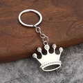 Portachiavi a corona in argento con strass scintillanti su fondo in legno rustico - Corona Grande