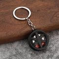 Dettaglio di un portachiavi a forma di cerchione auto con pinza freno rossa e disco argentato - Nero