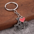 Gros plan du porte-clés I Love DAD avec cœur rouge sur un fond de texture boisée - Petit DAD (I ❤️ DAD)