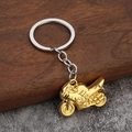 Goldener 3D Motorrad Schlüsselanhänger mit Silberring auf Holz und Stein - Gold