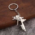 Silver zinc alloy spray gun keychain with realistic details on wood and stone background - Silver