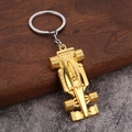 Dettaglio portachiavi auto F1 dorato in lega di zinco su superficie in legno scuro - Oro