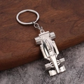 Elegante portachiavi per auto da corsa F1 in metallo argento su sfondo di legno e pietra - Argento