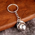 Polished silver metal mini safety helmet keychain displayed on a rustic wood surface - Silver