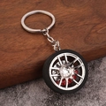 Close-up van autosleutelhanger met zilveren velg en rode remklauw details - Zilver
