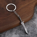 Macro detail of metal survival knife keychain with CrossFire engraving on wooden surface - Serrated Survival Knife (008)