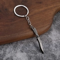 Macro view of Reaver Vandal metal tactical knife keychain on a wooden texture base - Gun Grey Tactical Folding Knife (006)