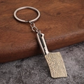 Detailaufnahme vom Küchenmesser-Schlüsselanhänger mit Damaststahl-Muster auf Goldklinge - Antike Bronze Hackmesser
