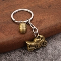 Portachiavi moto vintage in lega con pendente casco su sfondo in legno rustico - Bronzo