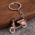 Vintage bronze motorcycle scooter keychain made of zinc alloy on wooden background - Antique Red Copper Scooter