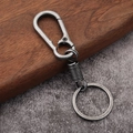 Vintage spring-loaded metal keychain with industrial antique silver finish on wood background - Antique Pewter