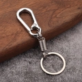 Polished silver spring keychain with D-ring carabiner on a rustic wood and stone background - White K/Silver