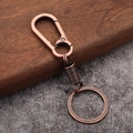 Detail of vintage copper spring keychain with lobster clasp on a textured background - Antique Red