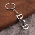 Silver metal DAD letter keychain with mustache detail on brown wood and stone surface - Silver Mustache DAD