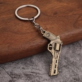 Detailopname van een vintage bronzen revolver sleutelhanger met fijne gravures - Stijl B Vuursteenslot (Antiek Brons)