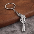 Detail showing vintage silver revolver keychain with fashion engraving on wood and stone - Style B Flintlock (Antique Pewter)