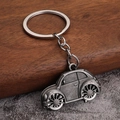 Close-up of vintage silver car keychain with metallic texture and intricate wheel details - Antique Pewter