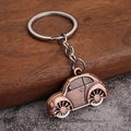 Close-up of vintage bronze beetle car keychain with detailed metallic texture and key ring - Antique Red