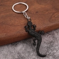 Macro shot of detailed black matte lizard gecko keychain with fine scale textures - Black