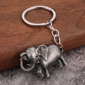 Dettaglio di un portachiavi a forma di elefante in argento vintage su legno scuro - Peltro antico