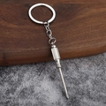 Close-up of a 3D mini silver Phillips screwdriver keychain made of polished alloy - Screwdriver