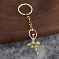 Golden ballet dancer keychain pendant with green crystal skirt and white rhinestones - Light Green