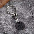 Porte-clés jeton de caddie en métal avec pièce noire sur un fond de pierre grise - Noir Mat