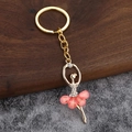 Dettaglio di ciondolo ballerina dorata con gonna a petalo rosa e strass luccicanti - Rosa