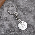Macro shot of silver metal shopping trolley coin keychain with lobster clasp on stone surface - Chrome