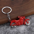 Dettaglio di un portachiavi a forma di moto rossa con ruote mobili e finitura metallica - Rosso