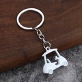 Dettaglio di un portachiavi a forma di golf cart 3D bianco con anello in metallo su legno - Bianco