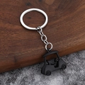Portachiavi 3D a forma di golf cart nera con anello in metallo su sfondo di legno - Nero