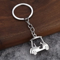 Close-up of polished silver golf cart keychain with realistic steering wheel and tire details - White K/Silver
