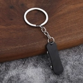 Makro-Detail des Mini-Skateboard-Anhängers in Schwarz mit realistischen Silberrädern - Schwarz