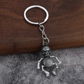 Dettaglio di un portachiavi a forma di teschio in bronzo con giunti mobili e stile vintage - Stagno Antico